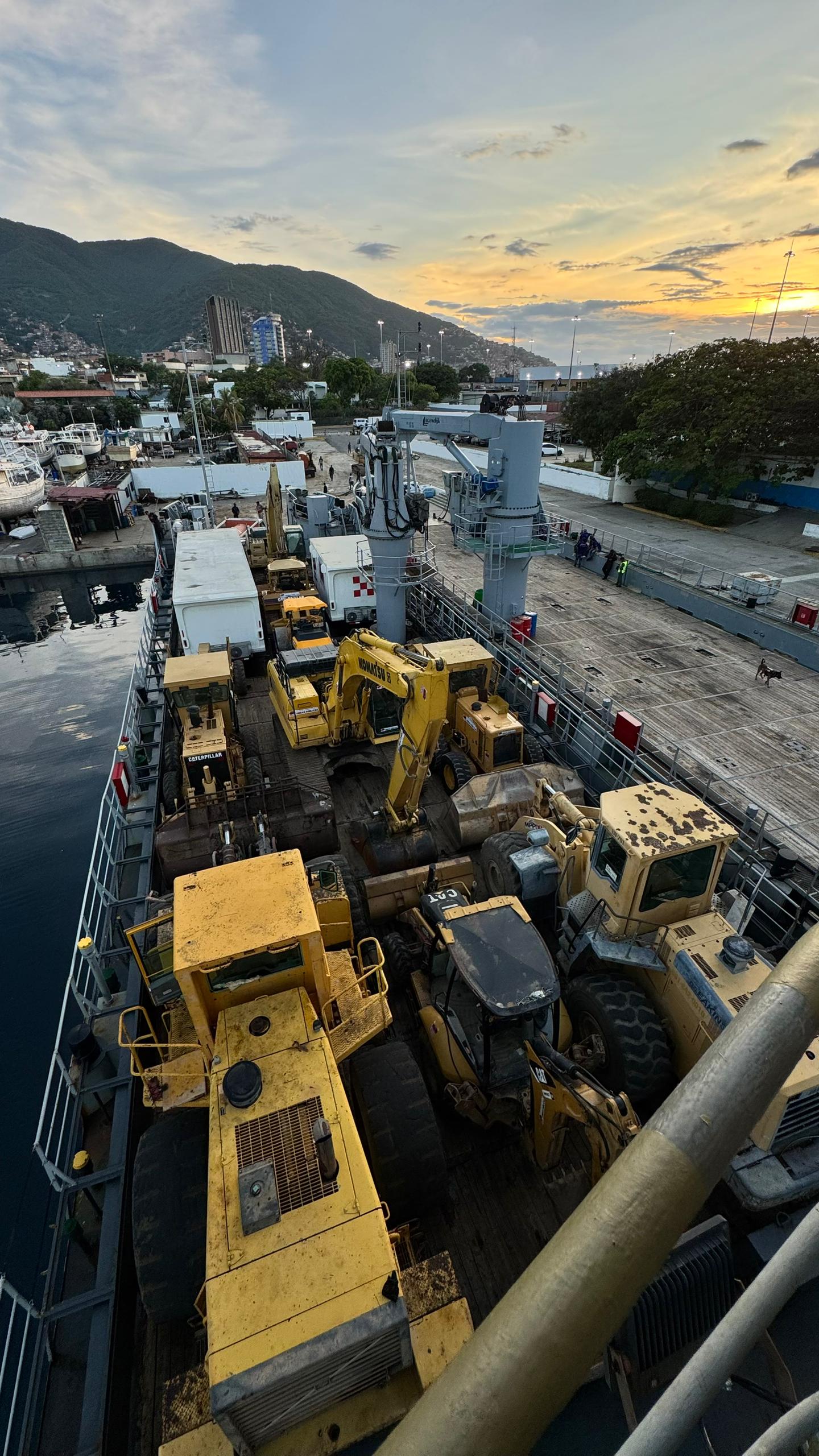 Maquinaria pesada estibada sobre embarcación en muelle