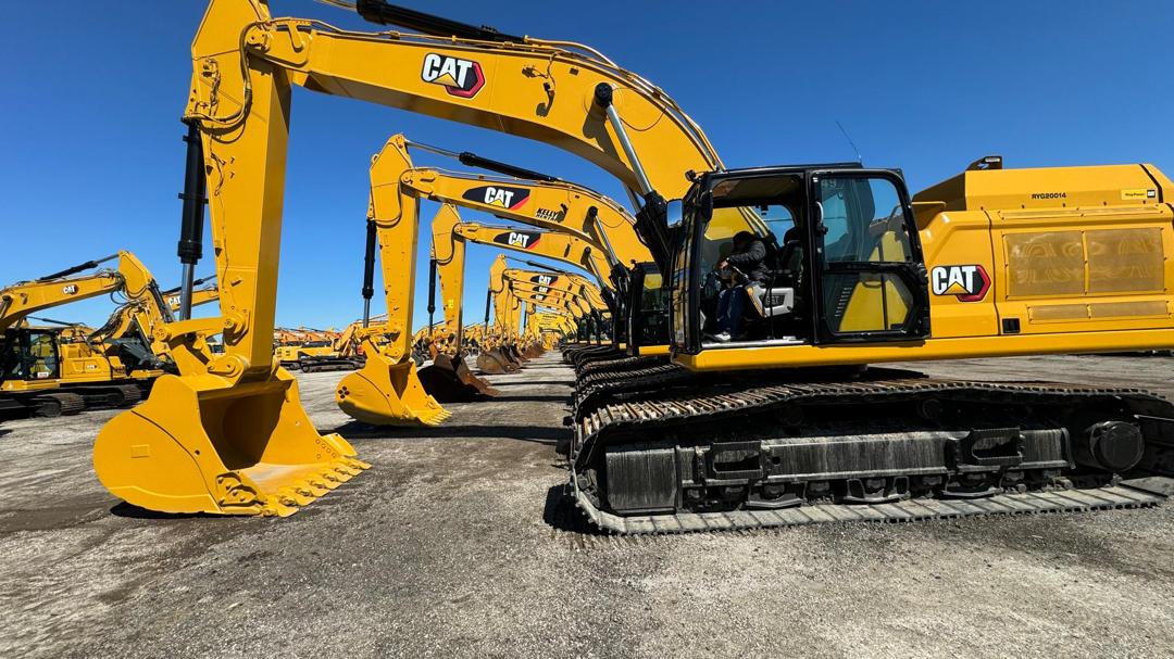 Fila de excavadoras CAT en patio de maquinaria